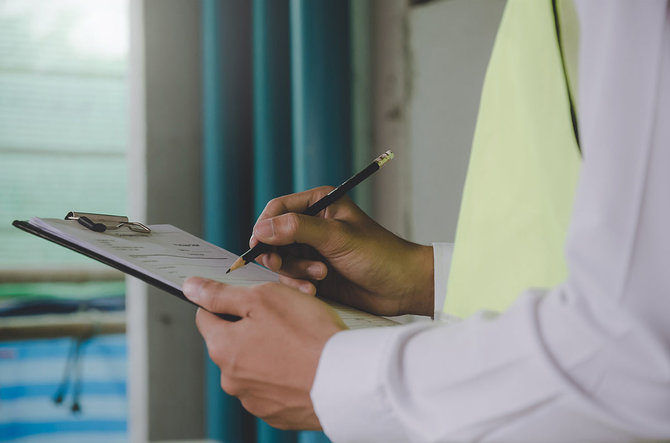 Person schreibt mit Bleistift auf Block